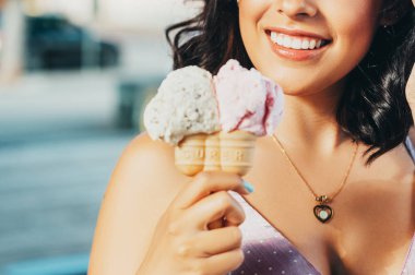 Genç güzel kadın, Stracciatella ve Bubble Gum tadı tarafından tutan çift koni dondurma