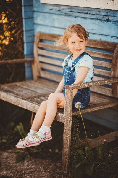 ベンチに座っているかわいい女の子の屋外の肖像画 田舎で幸せな子供時代 — ストック写真