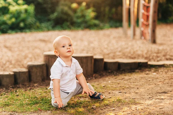 在阳光明媚的日子里在公园里玩耍的可爱一岁男婴的户外肖像 — 图库照片