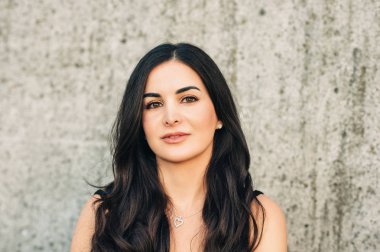 Uzun siyah saçlı çekici genç kadının dış portresi