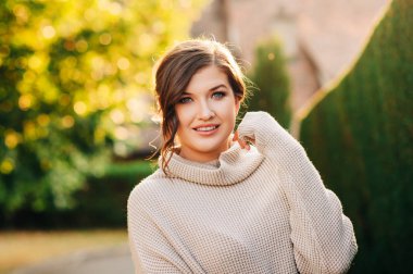 Sıcak rahat örme pullover giyen güzel genç kadının Altın saat portresi