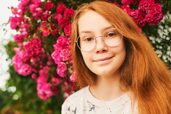 屋外クローズアップポートレートの幸せな若い女の子 眼鏡をかけて 花の庭にポーズ — ストック写真
