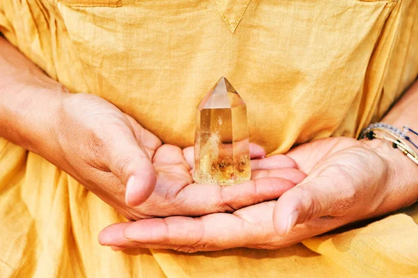 Citrine kristalinin bir kadın tarafından tutulan görüntüsünü kapat