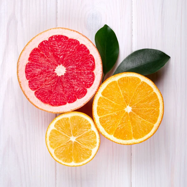 Beyaz ahşap arka planda renkli turunçgil meyveleri