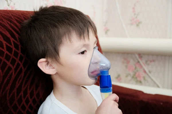 sick boy in nebulizer mask making inhalation, respiratory procedure by pneumonia or cough for child,  inhaler, compressor nebulizer,  nebules machine for health care. Kid catch cold