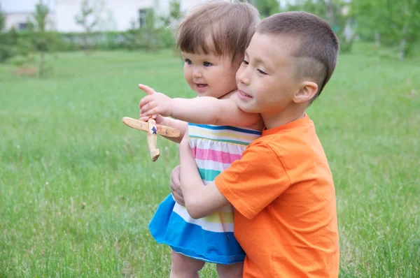 家庭生活方式 大哥在照看小妹妹 孩子们在公园里玩户外游戏玩得很开心 男孩拥抱小女婴 夏季活动与儿童 — 图库照片