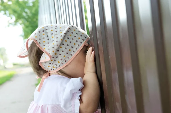 小女孩在栅栏里窥视洞 孩子看东西 — 图库照片