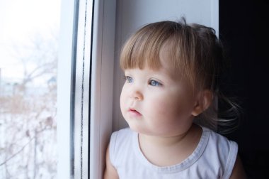 küçük çocuk pencereden dışarı bakarak. Bebek kız açık havada yürümek yağmurlu hava özlem. 