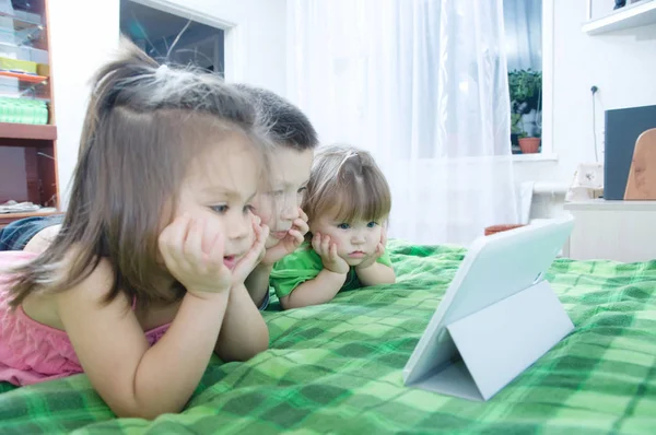 孩子们躺在家里的床上看着垫子 孩子们的时间花 使用平板电脑的孩子 — 图库照片