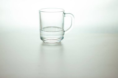 Gri arka planda şeffaf cam su. Masadaki taze içecek suyu arıtılmış