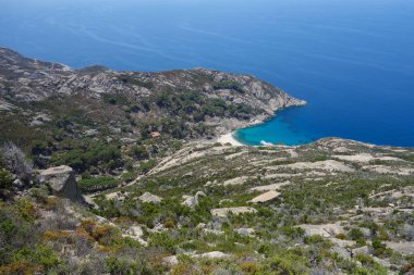 İtalya 'nın Portoferraio kentindeki Toskana Takımadası' nın Tyrhenian Denizi kıyısındaki Montecristo Adası 'ndaki Cala Maestra plajı.