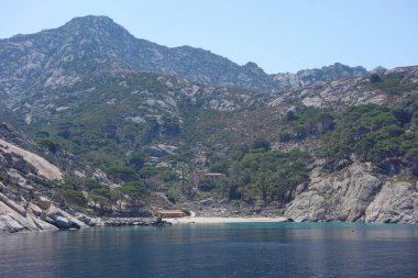 İtalya 'nın Portoferraio kentindeki Toskana Takımadası' nın Tyrhenian Denizi kıyısındaki Montecristo Adası 'ndaki Cala Maestra plajı.