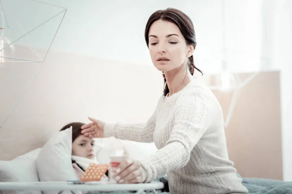 Внимательная брюнетка поддерживает своего больного ребенка — стоковое фото