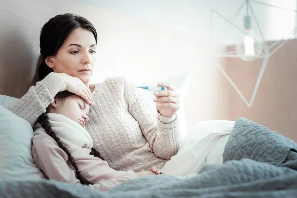 Figyelmes barna nő hőmérséklet ellenőrzése — Stock Fotó