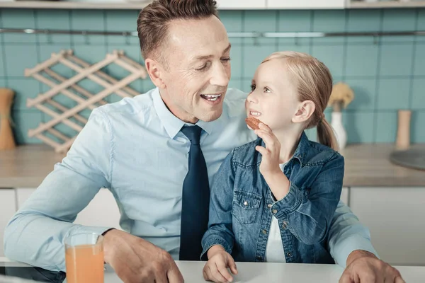 Neşeli erkek kişi onun çocuğun yanına oturuyor