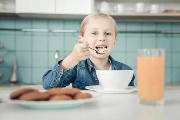 Criança encantada positiva tomando café da manhã — Fotografia de Stock