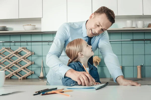 Encantada chica haciendo la tarea con su padre — Foto de Stock