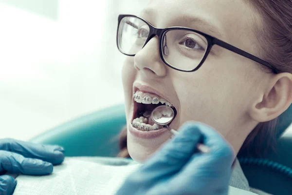Bir dişçi klinikte oturan Gözlüklü kız — Stok fotoğraf