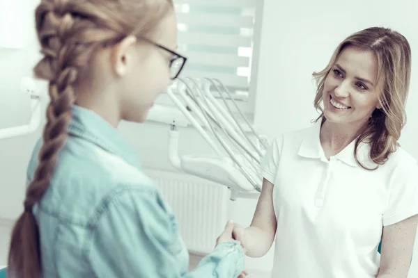 Trevlig ung kvinna skakar hand med en tjej — Stockfoto