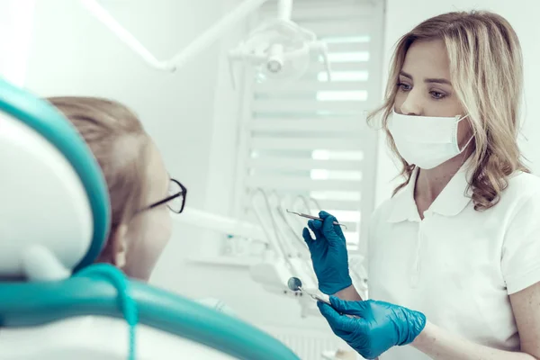 Νέοι όμορφη οδοντίατρος κρατώντας απαραίτητα Οδοντιατρικά εργαλεία — Φωτογραφία Αρχείου