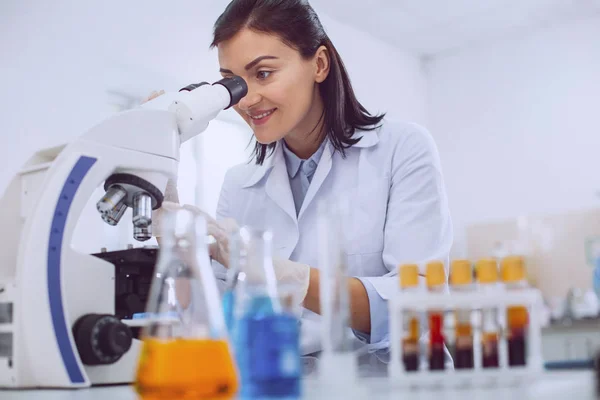 Delighted researcher looking into the microscope — Stock Photo, Image