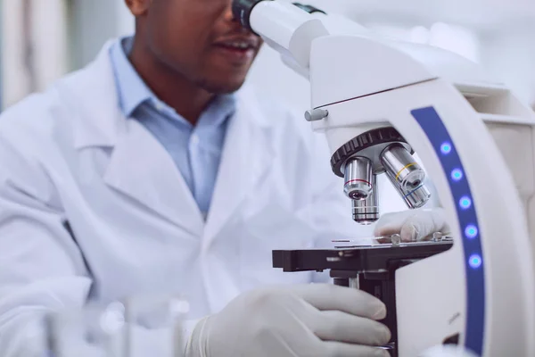 Biólogo alegre trabajando en un microscopio de vanguardia — Foto de Stock