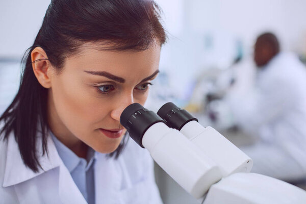 Умная женщина-биолог, работающая в лаборатории
