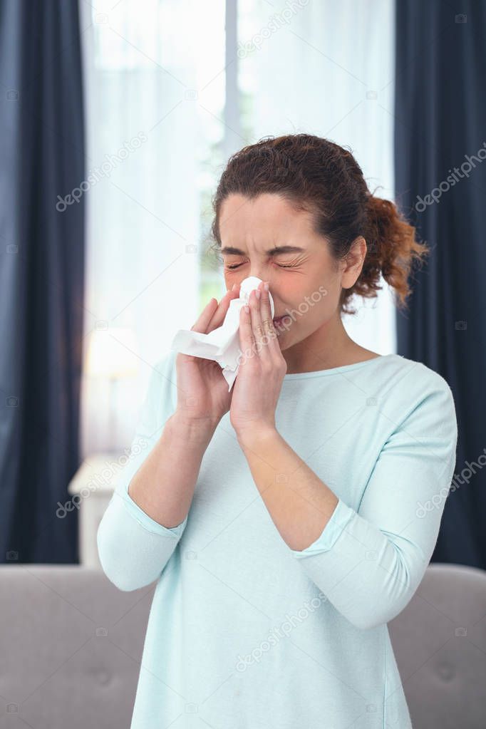 Woman cleansing up congested nose with a paper tissue