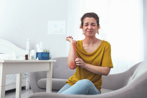 Молодая девушка с кожным заболеванием заставляет ее чесаться
