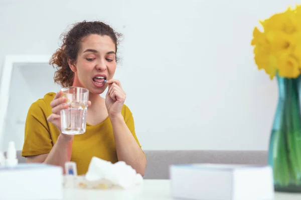 Paciente joven que se siente cauteloso mientras toma pastillas — Foto de Stock