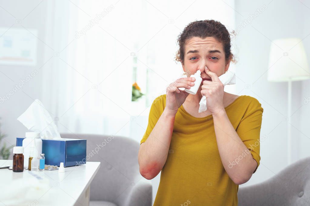 Young woman using nasal drops while following her doctors presription