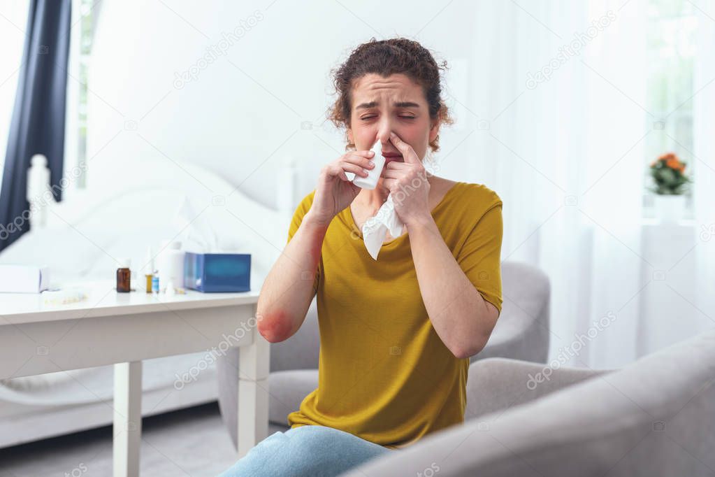 Young curly woman using nasal spray