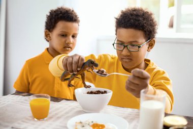 Onun kardeşi besleme oyuncak dinozor izlerken şirin küçük çocuk
