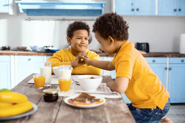 Niño pequeño burlándose de su hermano mayor durante el desayuno — Foto de Stock