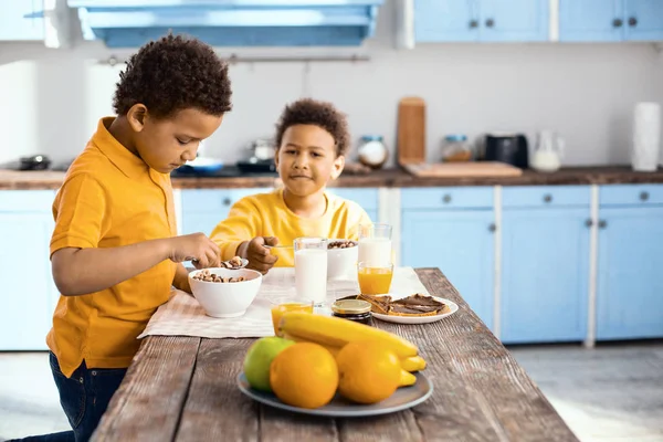 Pleasant little boys eating cereals for breakfast — Stock Photo, Image
