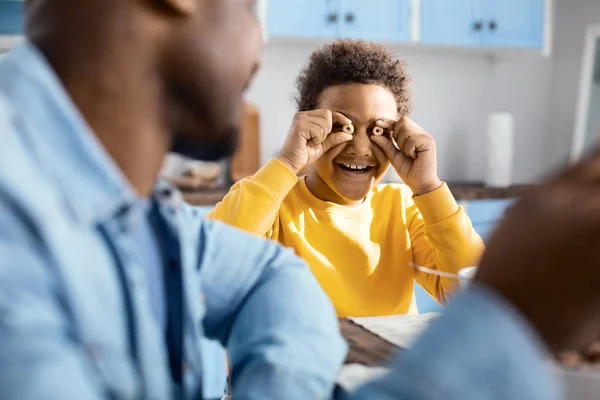 Joyful pre teen pojke klantar sig under frukosten — Stockfoto