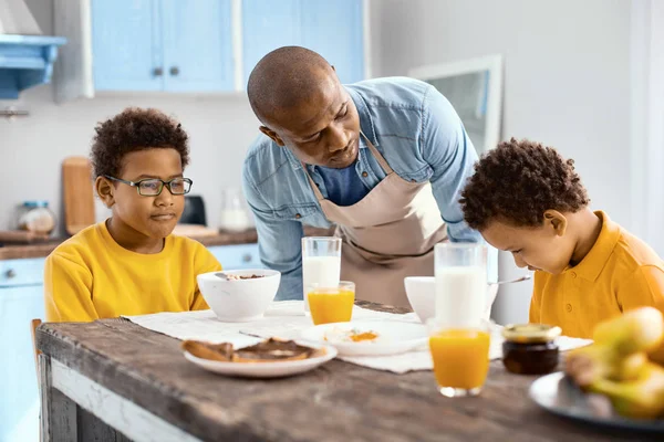 Padre cariñoso hablando con su hijo molesto en el desayuno — Foto de Stock