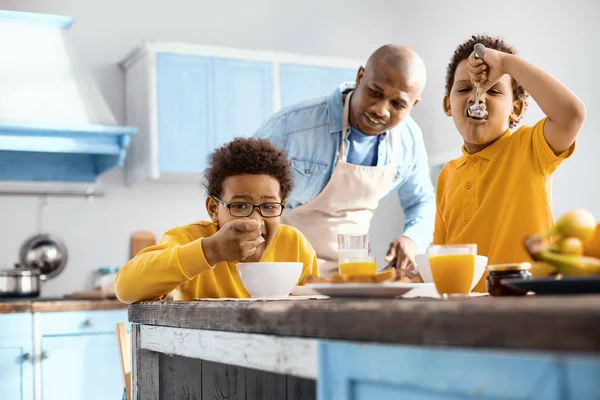 Cuidar al joven padre viendo a sus hijos desayunar — Foto de Stock