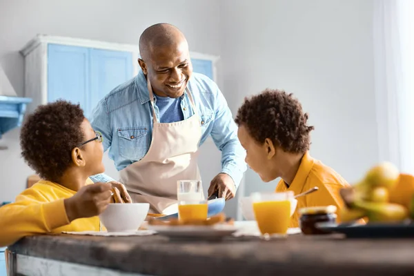 Padre feliz hablando con sus hijos mientras desayunan — Foto de Stock