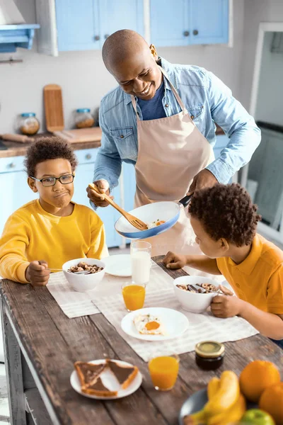 Encantador joven padre sirviendo a sus hijos tortilla para el desayuno — Foto de Stock