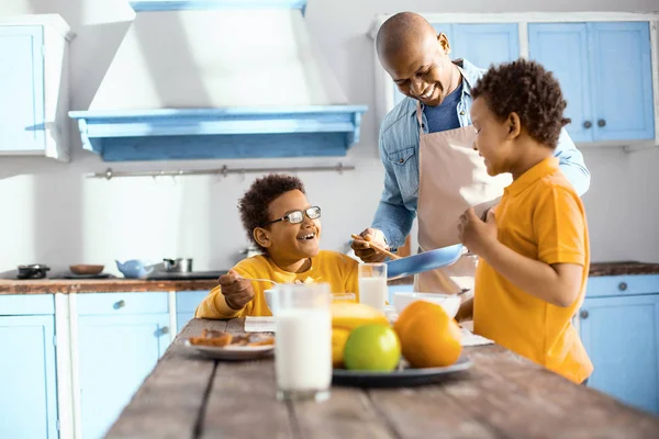 Optimistická otec povídal s dětmi při servírování omeletu — Stock fotografie