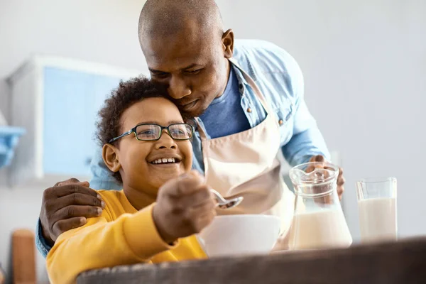 Cuidando joven padre abrazando a su pequeño hijo en el desayuno — Foto de Stock