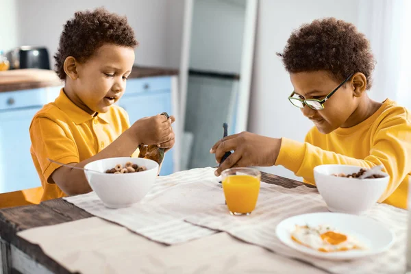 Dos hermanitos alimentando sus juguetes en la cocina —  Fotos de Stock