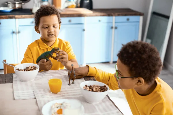 Fröhliche kleine Jungen spielen beim Frühstück — Stockfoto