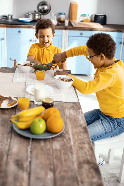 Optimistische kleine Jungen spielen Dinosaurier-Kampf in der Küche — Stockfoto