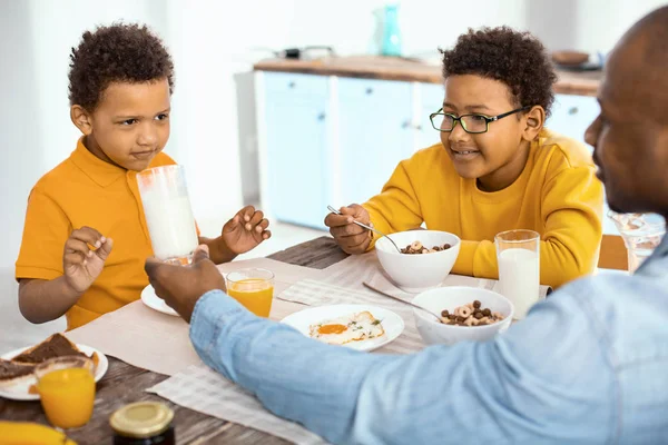 Agradable joven padre ayudando a su hijo a beber leche — Foto de Stock