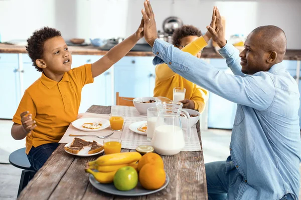 Upbeat single-parent family high-fiving each other at breakfast — Stock Photo, Image