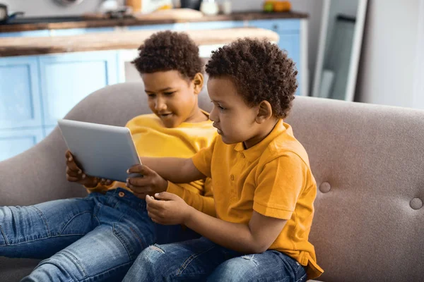Милые младшие братья смотрят мультики на планшете вместе — стоковое фото