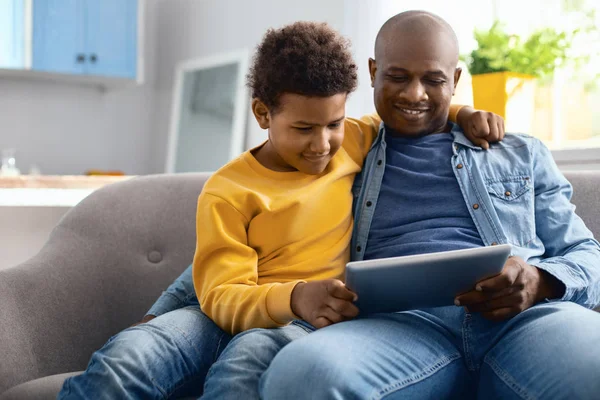 Alegre padre e hijo viendo videos en la tableta —  Fotos de Stock
