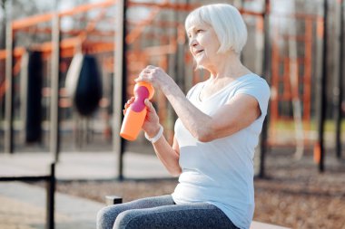 Bir şişe tutan uyarı yaşlı kadın